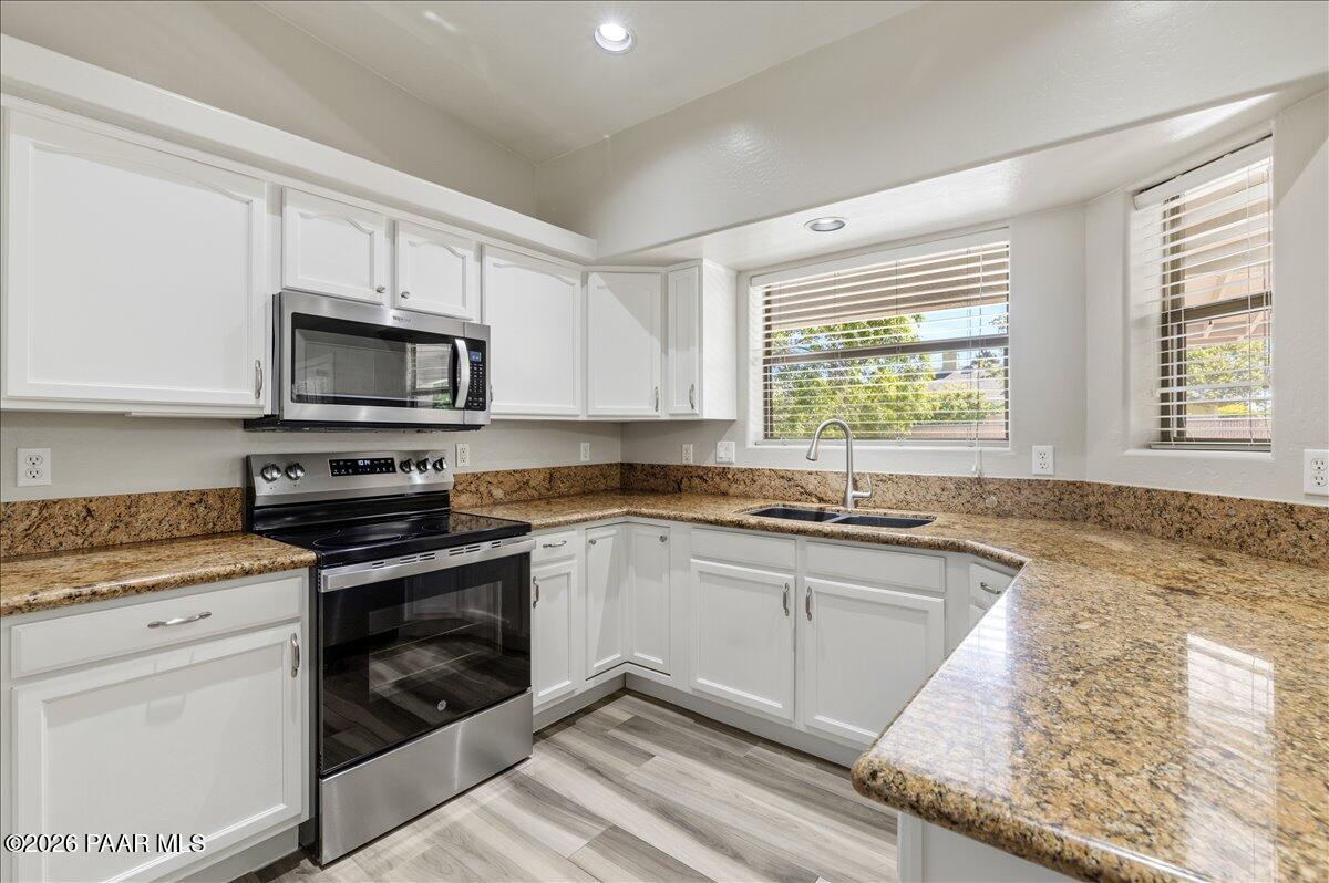 4701 North Spring Drive Prescott Valley, AZ 86314 - Photo 13 of 31 a kitchen with granite countertop a stove a sink and a microwave