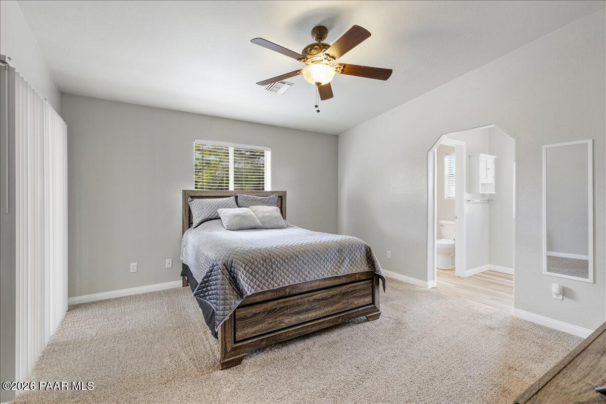 4701 North Spring Drive Prescott Valley, AZ 86314 - Photo 15 of 31 a spacious bedroom with a bed and a ceiling fan