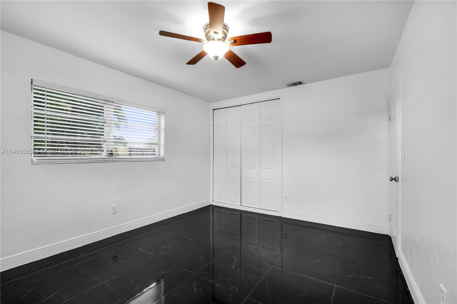 12371 Southwest 191st Street Miami, FL 33177 - Photo 14 of 19 a view of empty room with wooden floor and fan