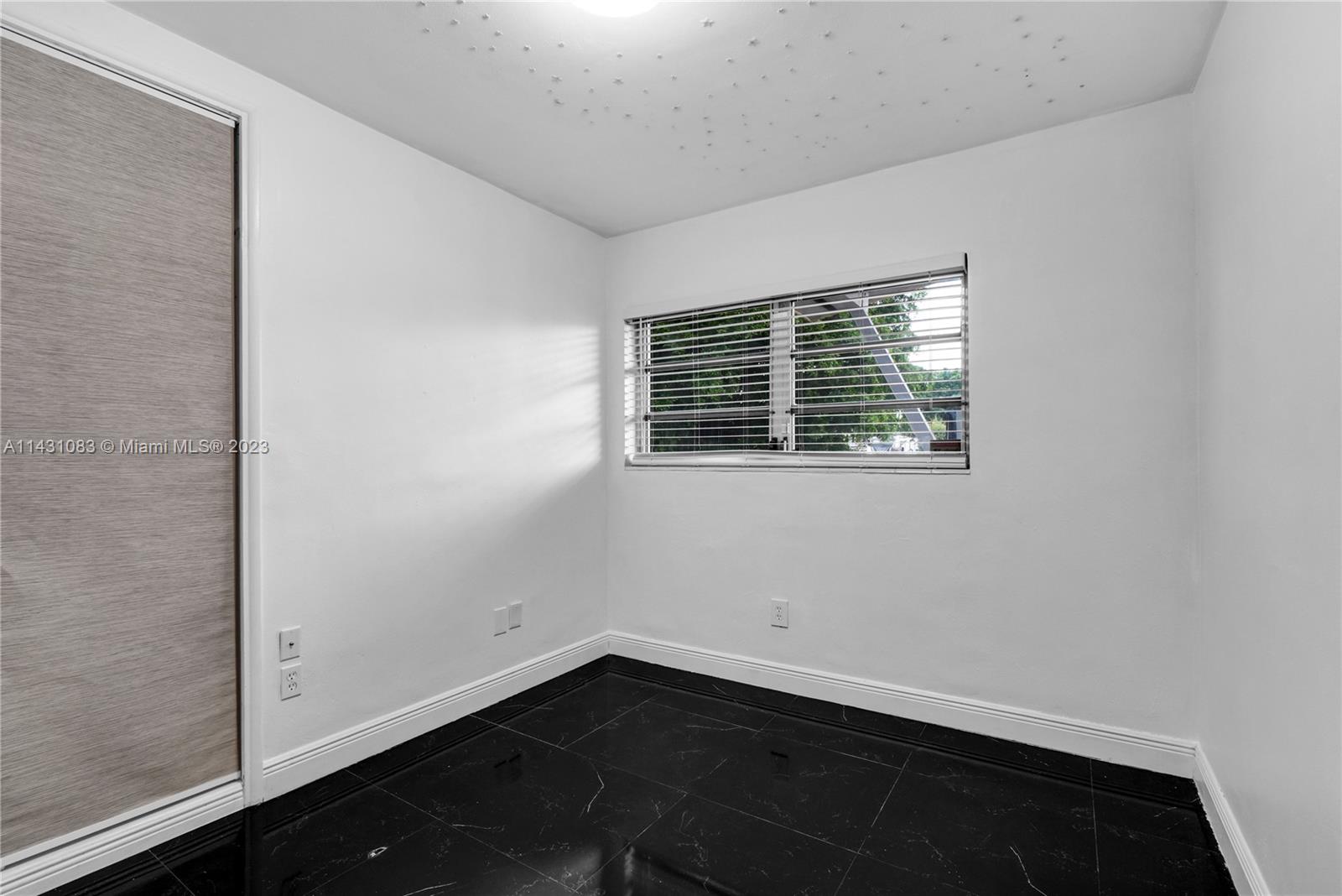 12371 Southwest 191st Street Miami, FL 33177 - Photo 17 of 19 a view of an empty room with wooden floor and a window