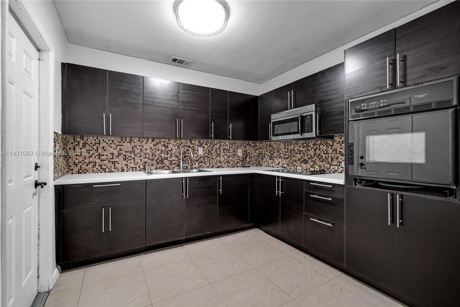 12371 Southwest 191st Street Miami, FL 33177 - Photo 5 of 19 a kitchen with stainless steel appliances kitchen island granite countertop a sink and stove