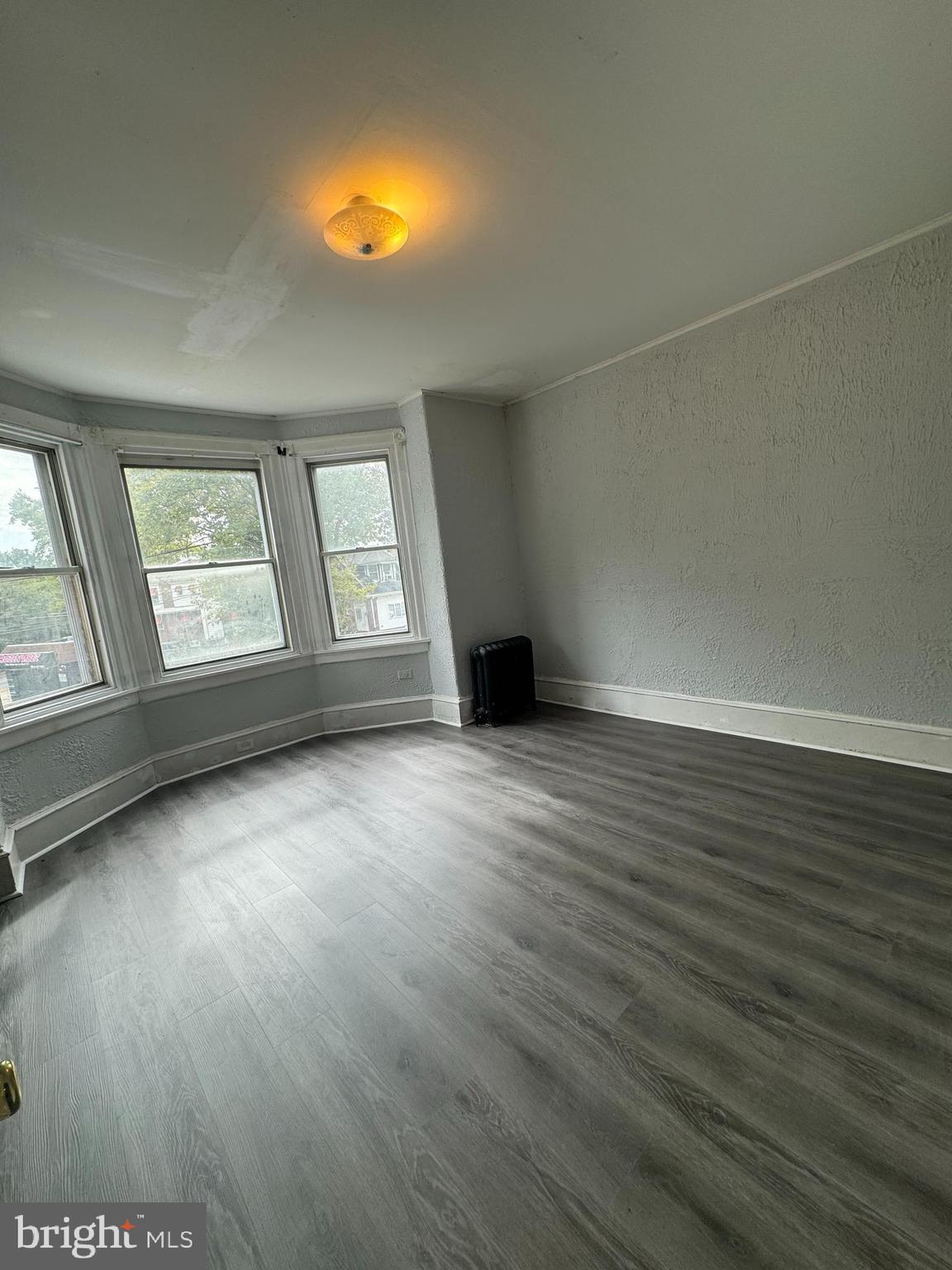 4660 Castor Avenue, Unit 2 Philadelphia, PA 19124 - Photo 4 of 11 an empty room with wooden floor and windows