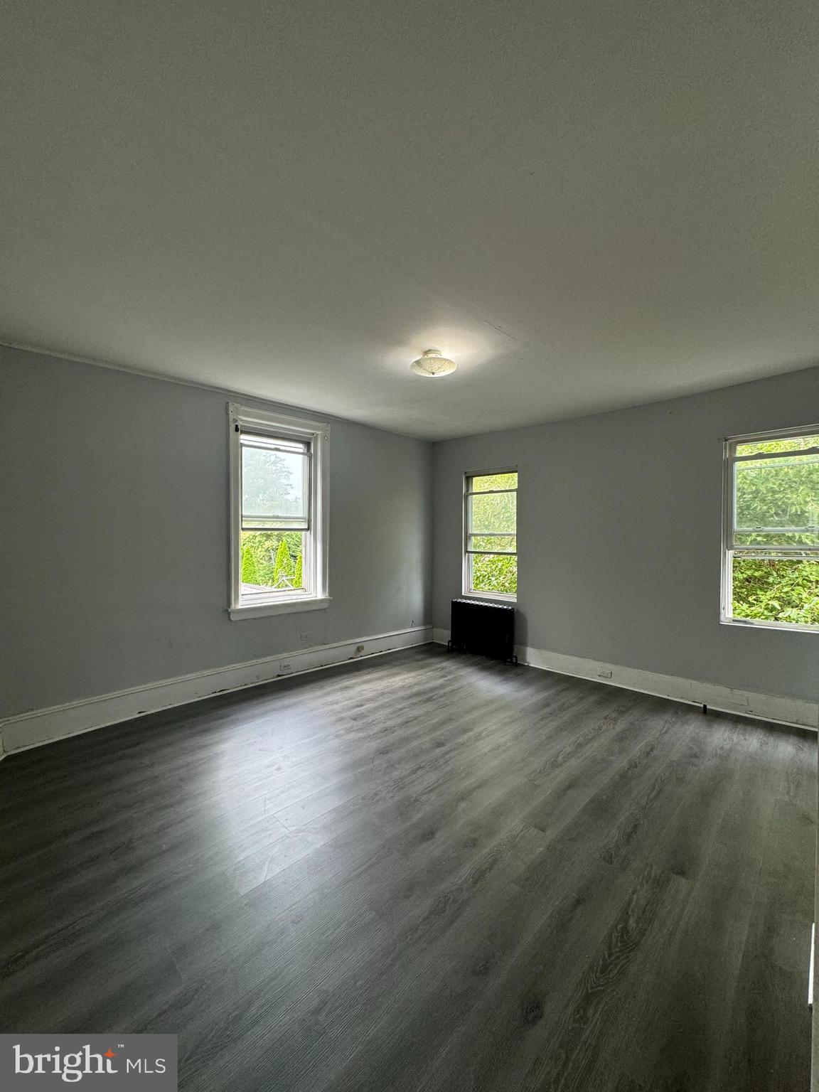 4660 Castor Avenue, Unit 2 Philadelphia, PA 19124 - Photo 6 of 11 an empty room with wooden floor and windows