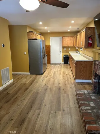 a large kitchen with stainless steel appliances granite countertop a refrigerator and a sink