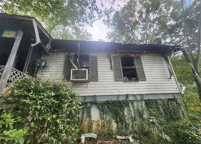 a view of house with yard and trees in the background