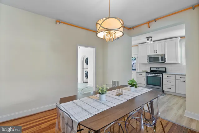 a view of dining room and kitchen island with wooden floor