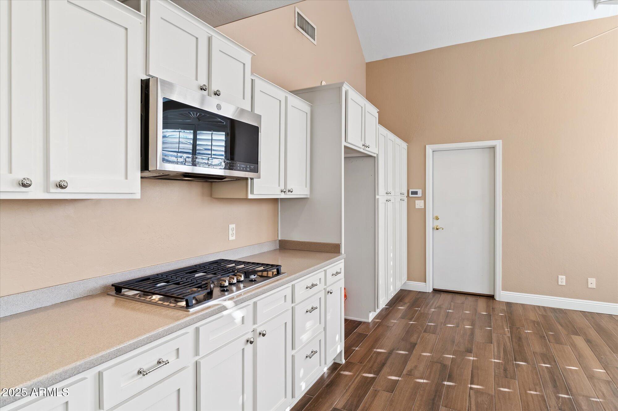 5534 North 15th Street Phoenix, AZ 85014 - Photo 9 of 25 a kitchen with stainless steel appliances a white cabinet and a stove top oven