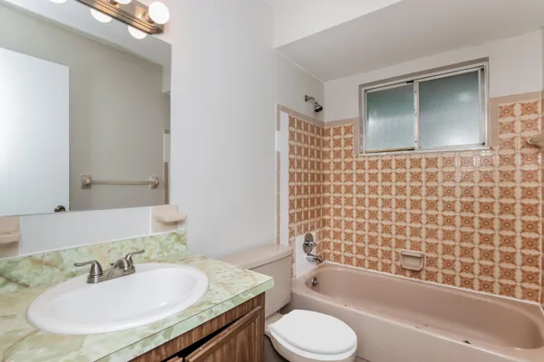 a bathroom with a granite countertop sink toilet and shower
