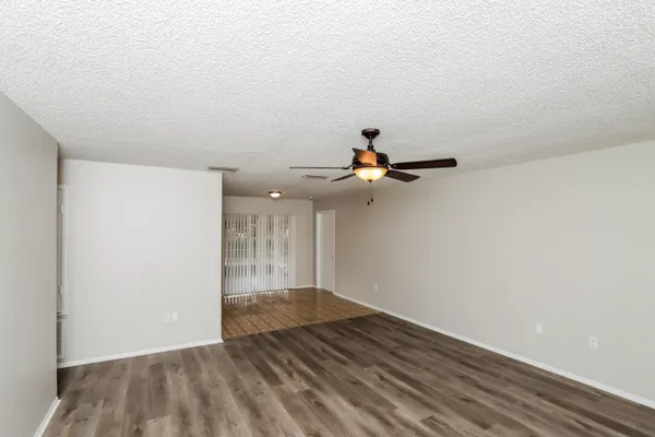 a view of a room with wooden floor and fan