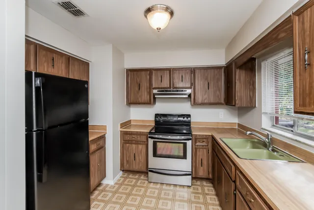 a kitchen with a refrigerator stove and sink