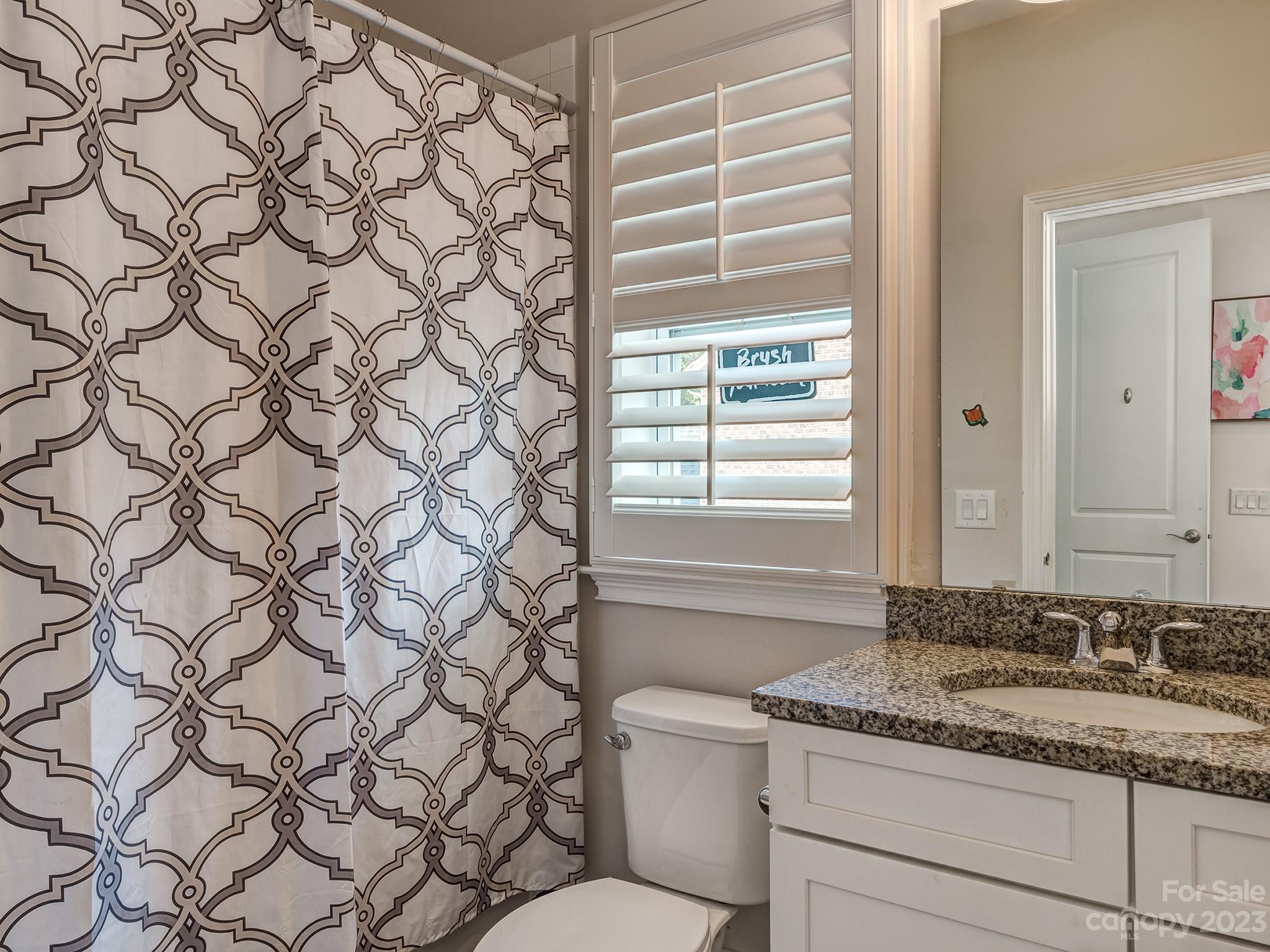 411 Turtleback Ridge Weddington, NC 28104 - Photo 33 of 48 a bathroom with a granite countertop sink and a toilet