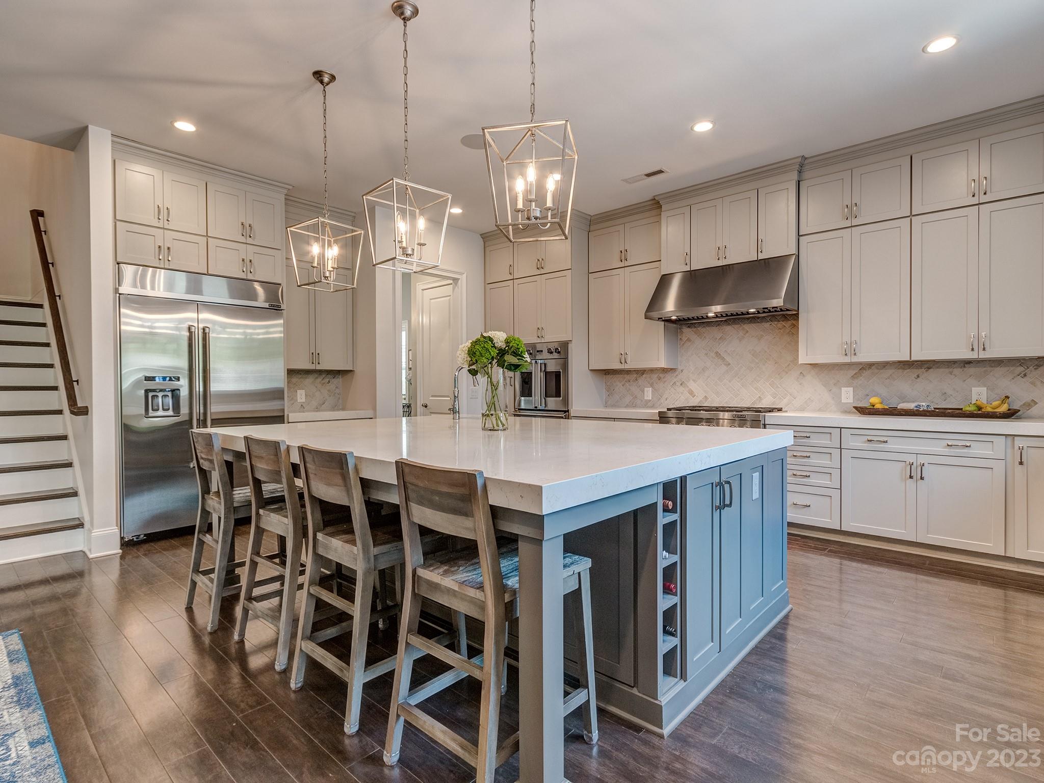 411 Turtleback Ridge Weddington, NC 28104 - Photo 6 of 48 a kitchen with stainless steel appliances kitchen island granite countertop a wooden floor and white cabinets