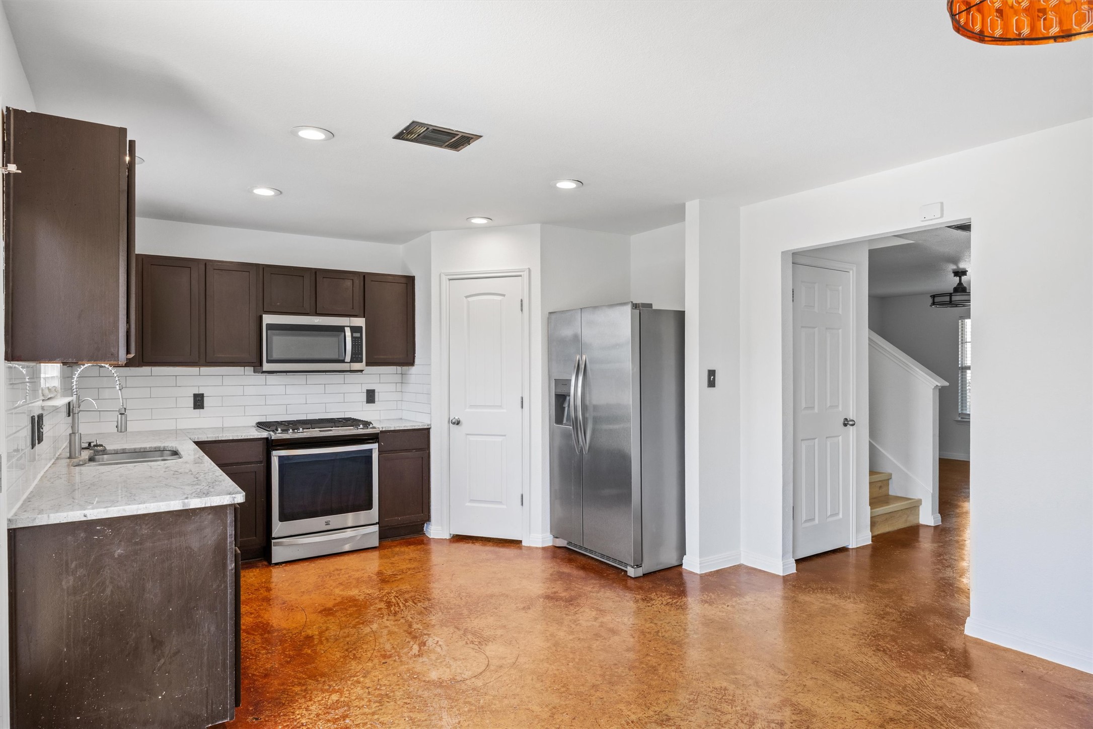 4516 Kind Way, Unit 253 Austin, TX 78725 - Photo 5 of 31 a kitchen with stainless steel appliances granite countertop a refrigerator a stove and a sink