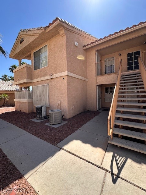 View of side of home with stairway, stucco siding,