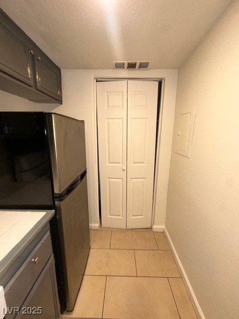 1830 North Pecos Road, Unit 155 Las Vegas, NV 89115 - Photo 13 of 23 Kitchen with fridge, baseboards, light tile patter