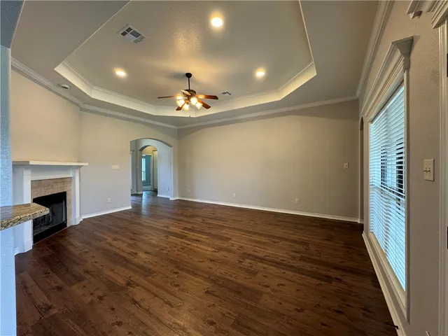 a view of an empty room with a fireplace and a window