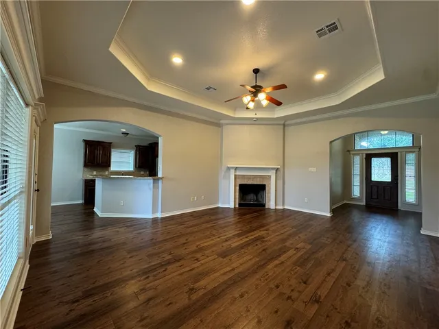 an empty room with wooden floor and fireplace