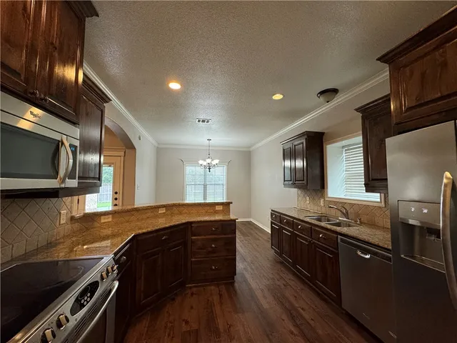 a kitchen with granite countertop a stove and a sink