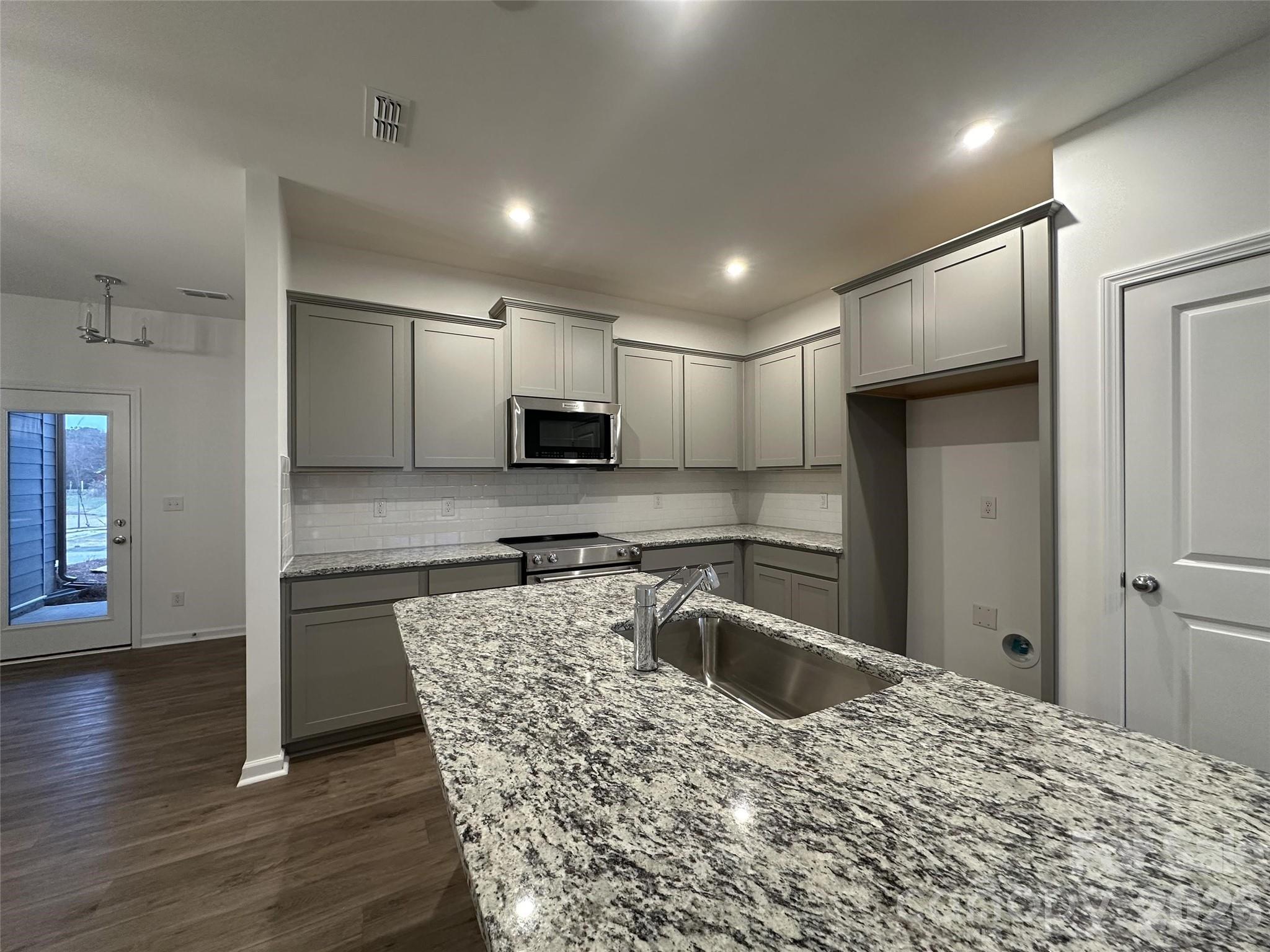 1872 Teachers House Road Northwest Concord, NC 28027 - Photo 5 of 14 a kitchen with stainless steel appliances granite countertop a refrigerator a sink a stove and cabinets