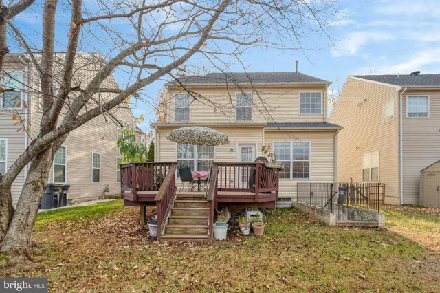 a view of a house with a wooden deck and furniture