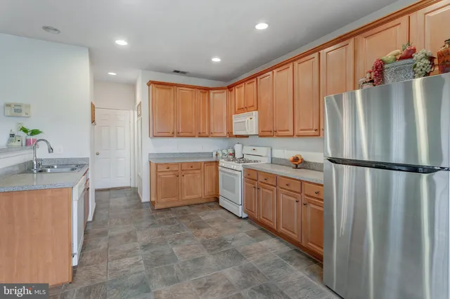 a kitchen with a refrigerator sink stove and cabinets