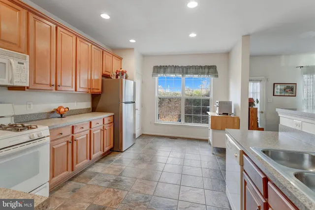 a kitchen with stainless steel appliances granite countertop a stove a sink dishwasher and a refrigerator