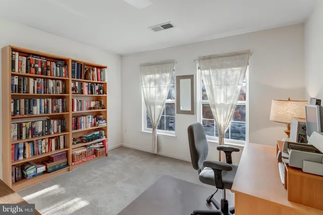 a view of a workspace with furniture and a bookshelf