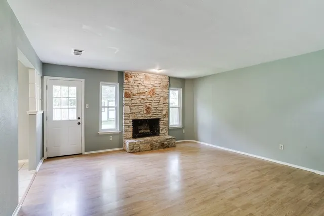 an empty room with fireplace and windows