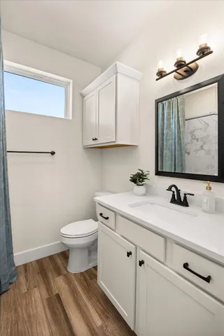 a bathroom with a sink toilet and mirror