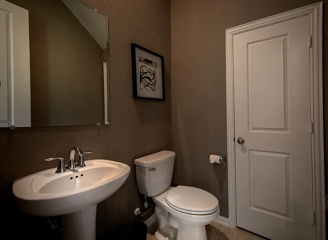 a bathroom with a sink toilet and a mirror
