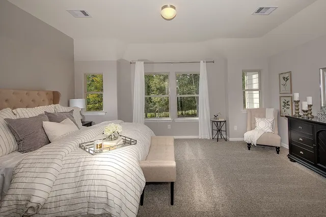 a bedroom with furniture and a large window