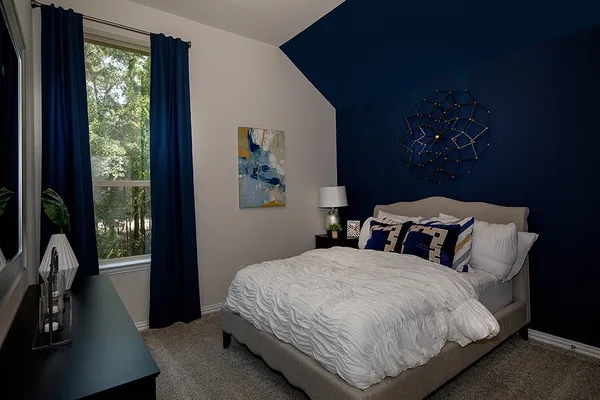 a bedroom with a bed and a large window
