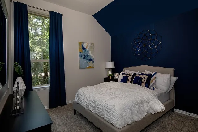 a bedroom with a bed and a large window