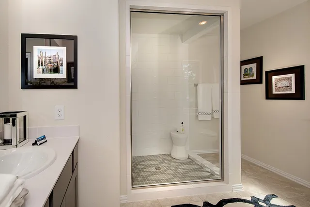 a bathroom with a granite countertop sink mirror and shower