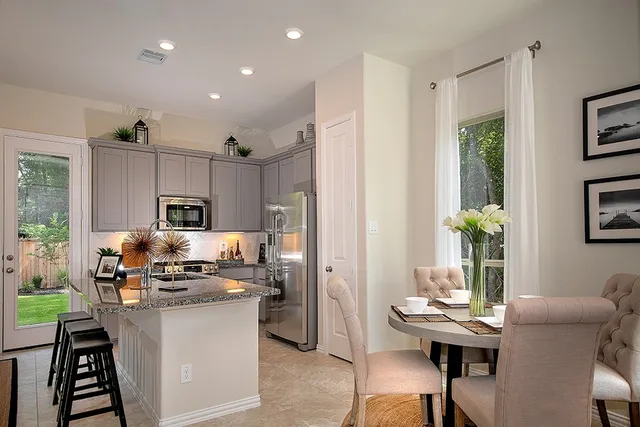 a kitchen with kitchen island granite countertop a stove and a refrigerator