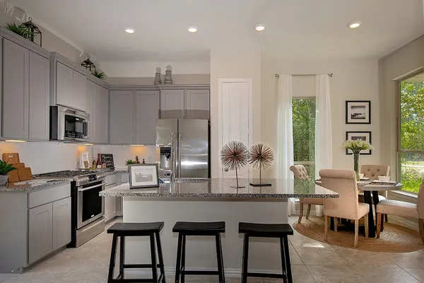 a kitchen with a table chairs refrigerator and cabinets