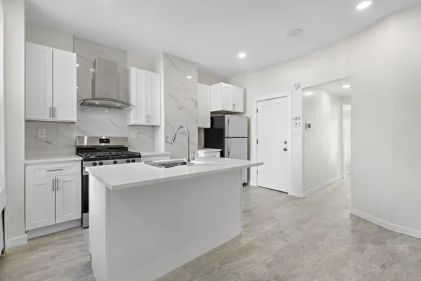 a kitchen with stainless steel appliances a stove refrigerator sink and cabinets