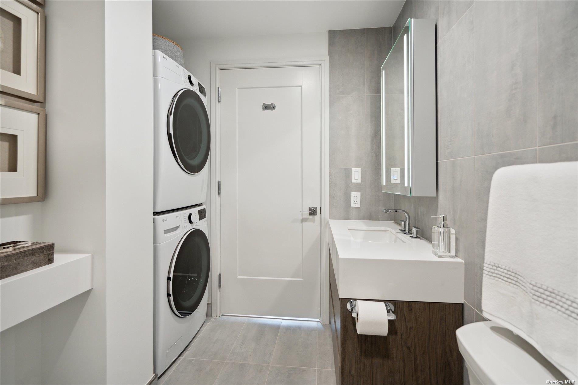 218 Middle Neck Road, Unit 107 Great Neck, NY 11021 - Photo 12 of 32 a bathroom with a sink a washer and dryer