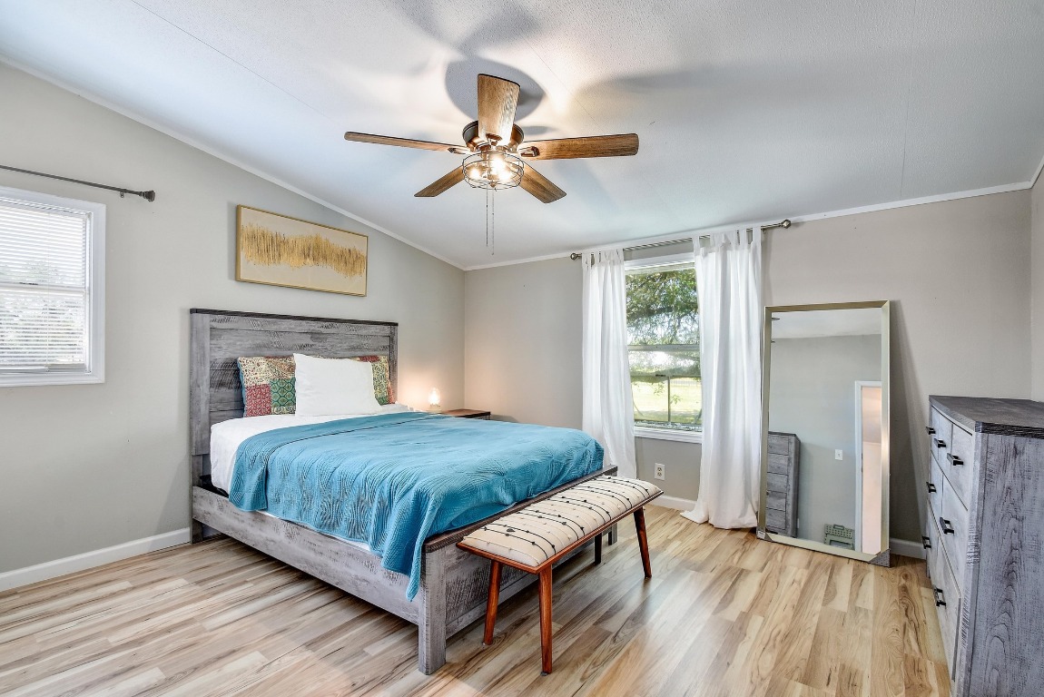 17398 Benton City Road Von Ormy, TX 78073 - Photo 12 of 25 a bedroom with a bed and a chandelier