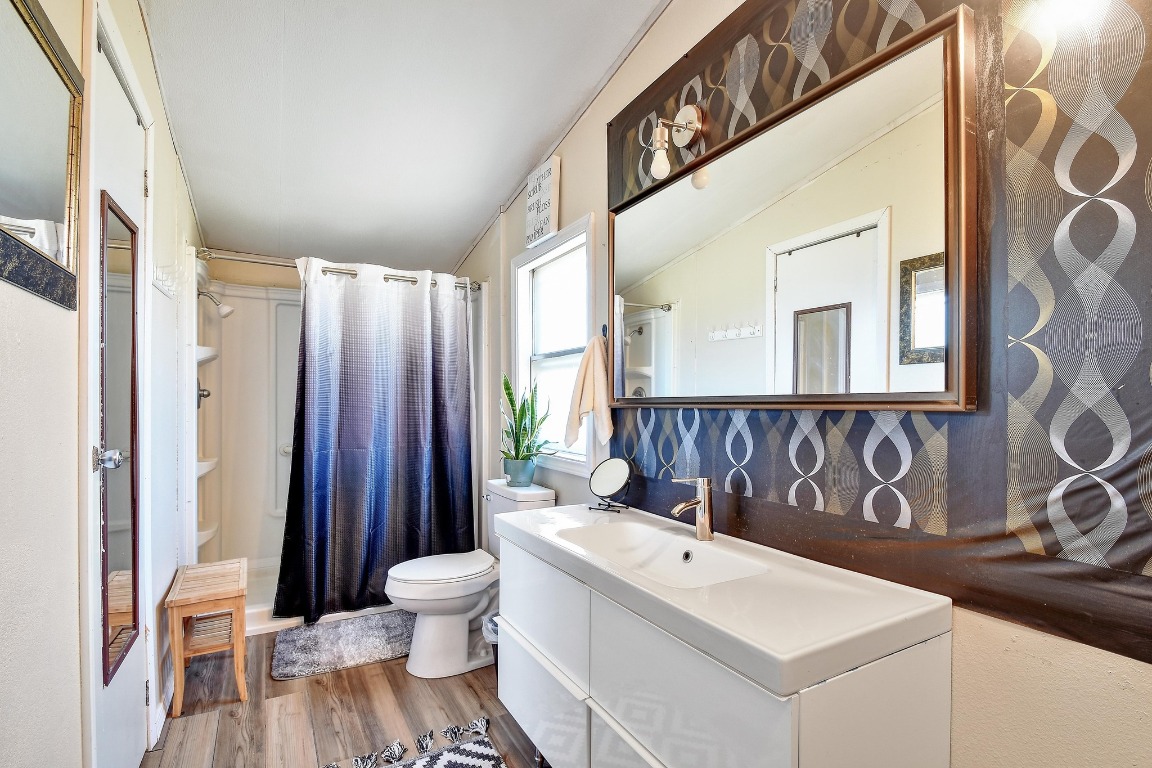 17398 Benton City Road Von Ormy, TX 78073 - Photo 14 of 25 a bathroom with a sink a toilet and mirror