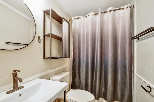 a bathroom with a sink a toilet and a mirror