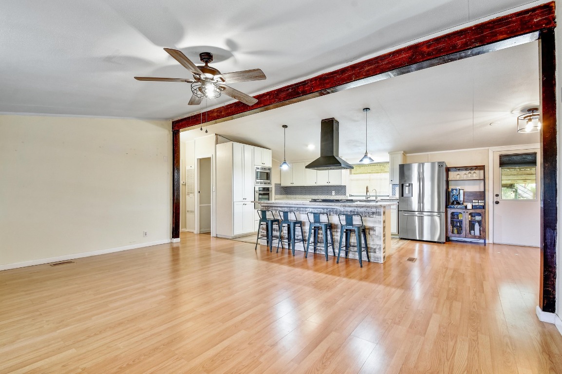 17398 Benton City Road Von Ormy, TX 78073 - Photo 4 of 25 a view of a kitchen with furniture and wooden floor