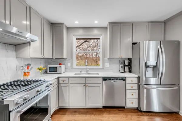 a kitchen with stainless steel appliances white cabinets and a refrigerator