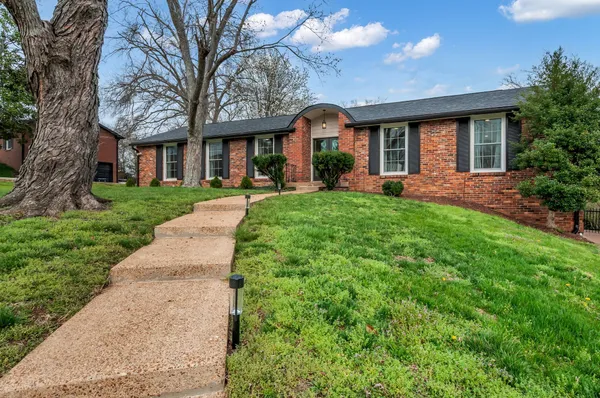 front view of a brick house with a yard