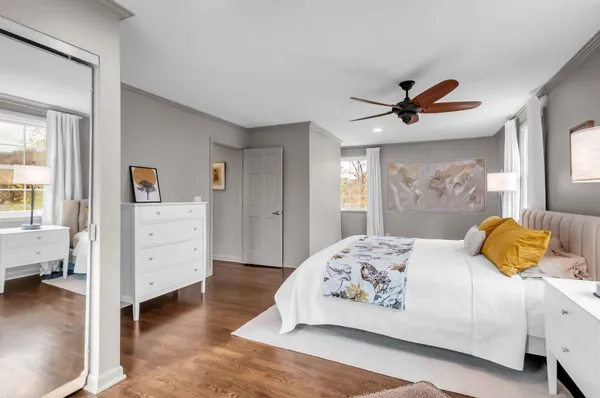 a bedroom with a bed a dresser and a window