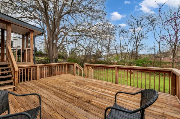 a balcony with wooden floor table and chairs