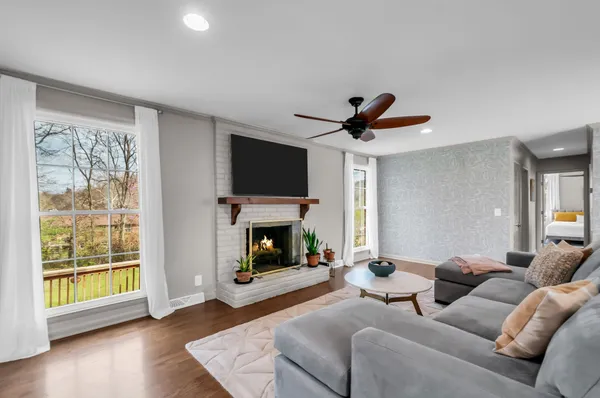 a living room with furniture a fireplace and a flat screen tv