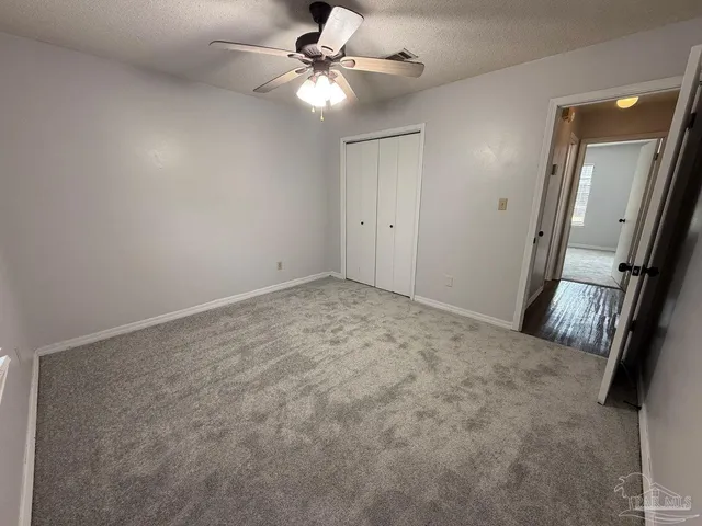 an empty room with a window and a fan