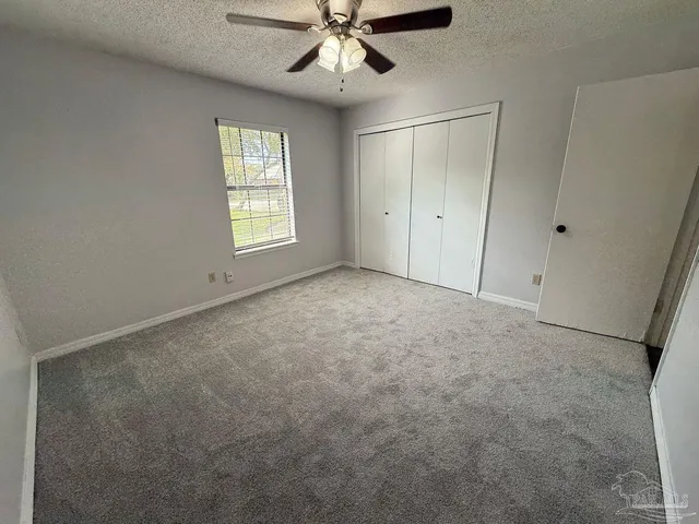 a view of a house with a big yard and large trees