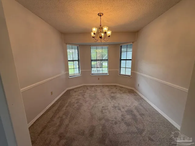 an empty room with windows and chandelier